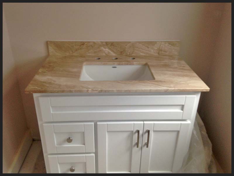 Daino Realle Marble bathroom counter with white cabinet.