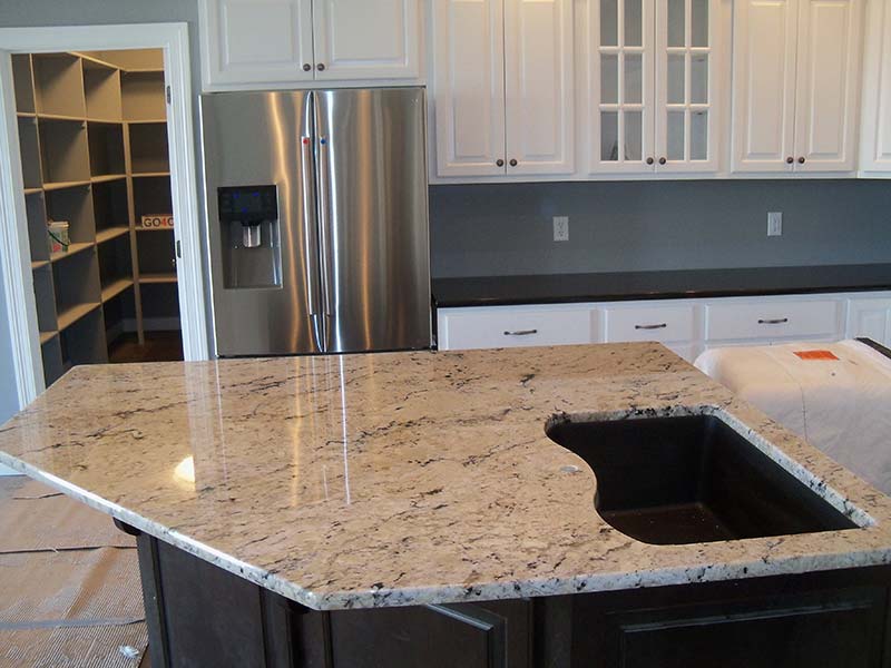 A close up of the cut out for the sink in this Delicatus Granite kitchen island counter.
