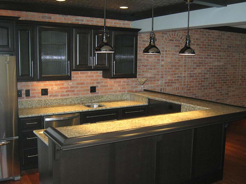 Juperana Gold Granite kitchen island and counters dark cabinets.