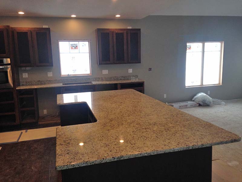 Juperana Gold kitchen island and dark cabinets.