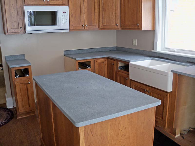 Black Soapstone kitchen island and counter, not oiled, over golden oak cabinets