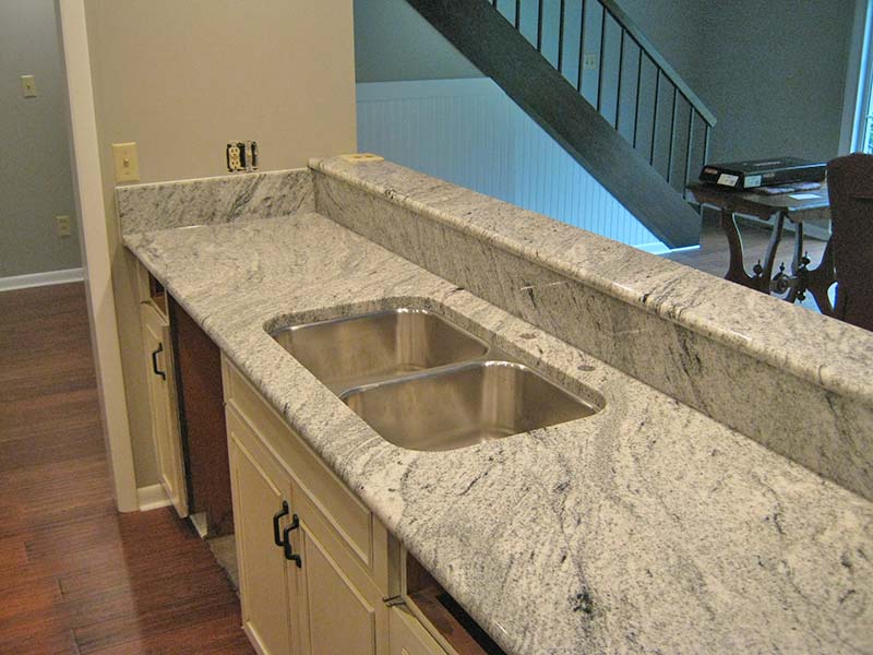 Viscont white Granite kitchen island with stainless steel double sink.