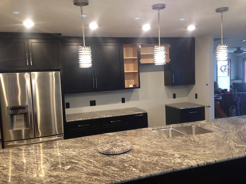 White Thunder Granite kitchen counter and dark brown cabinets, nice.