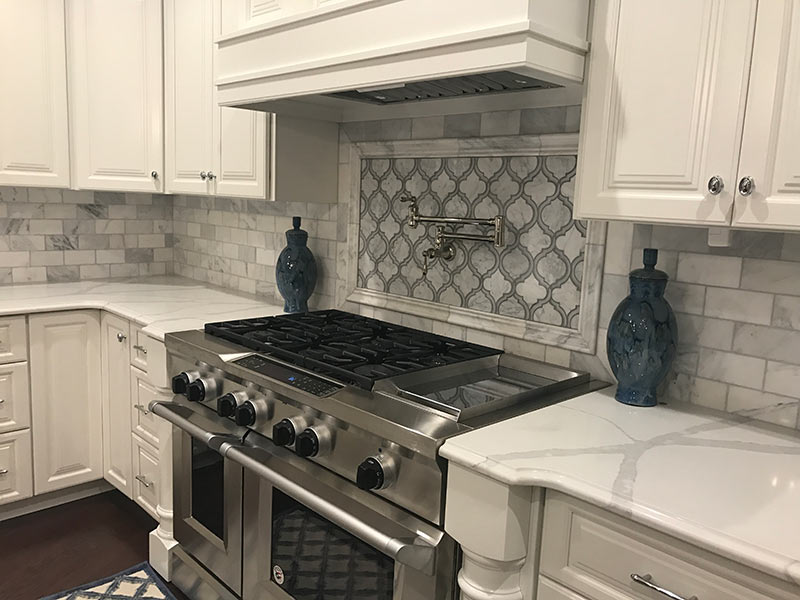 White Quartz with large vein pattern - close up of gas range and surrounding counter tops